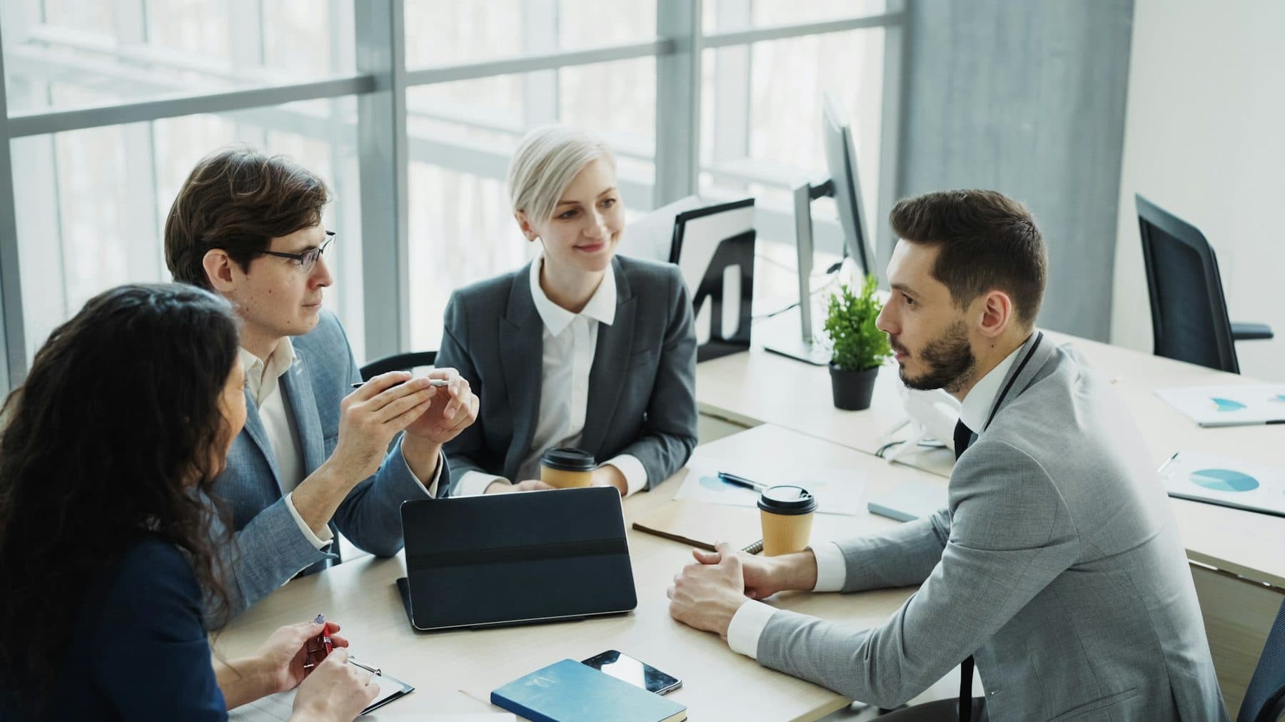 A team in discussion around a table in a bright, modern office
