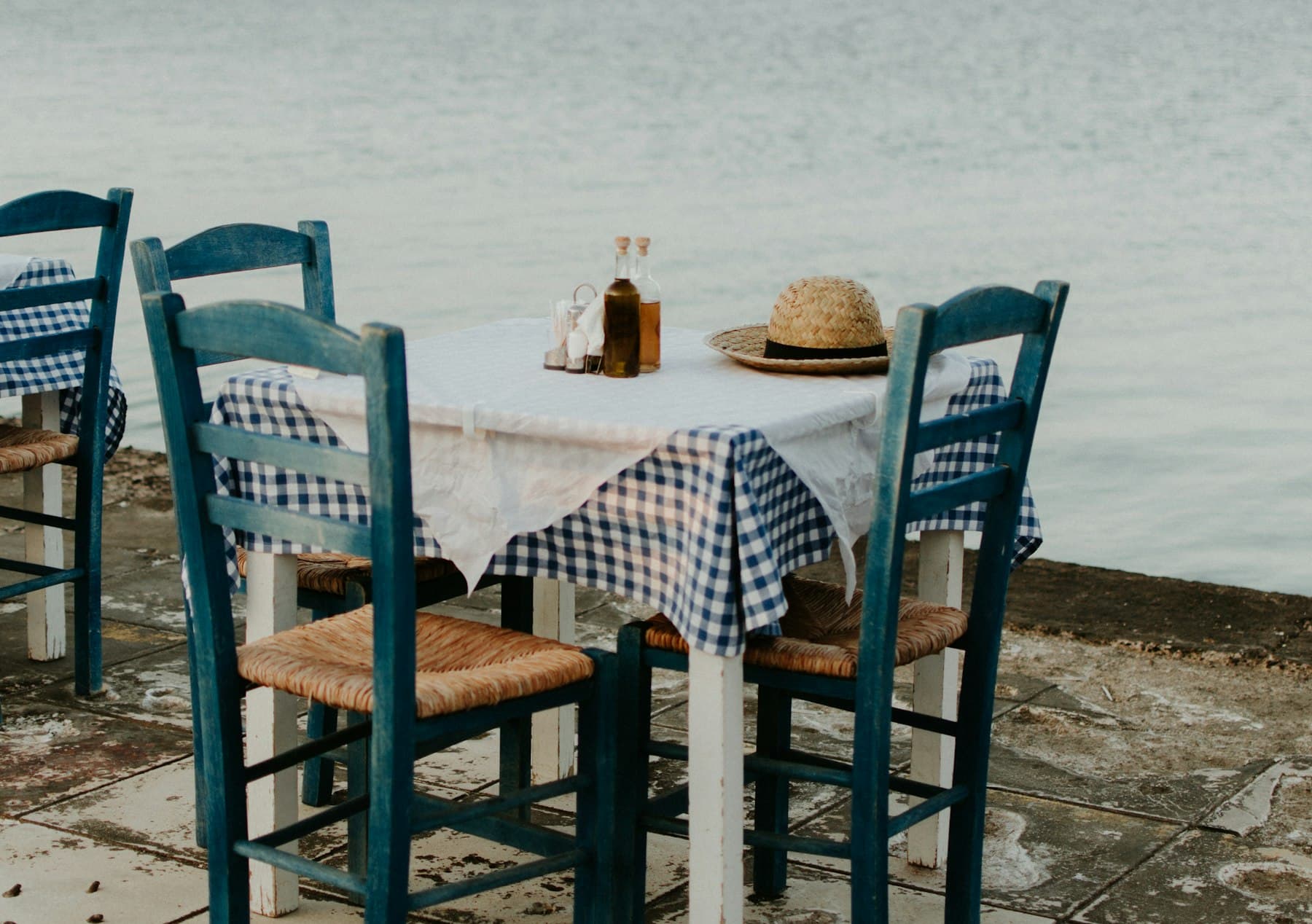 A shared table outside a Greek taverna, plates and glasses between friends